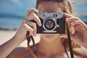 A woman on the beach taking a picture of her photographer