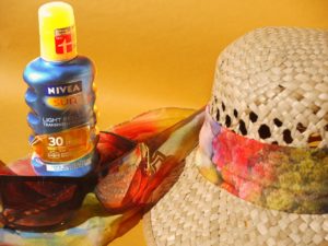 An image of vacation necessities: hat, sunglasses, sun screen