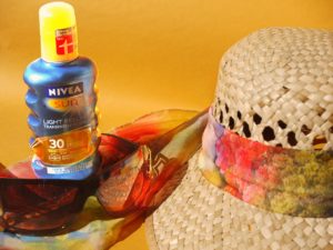 An image of vacation necessities: hat, sunglasses, sun screen