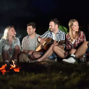 Adult couples having fun sitting around a campfire