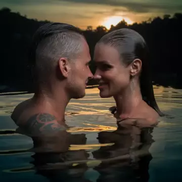 Adult couple gazing into each others eyes in a lake at sunset